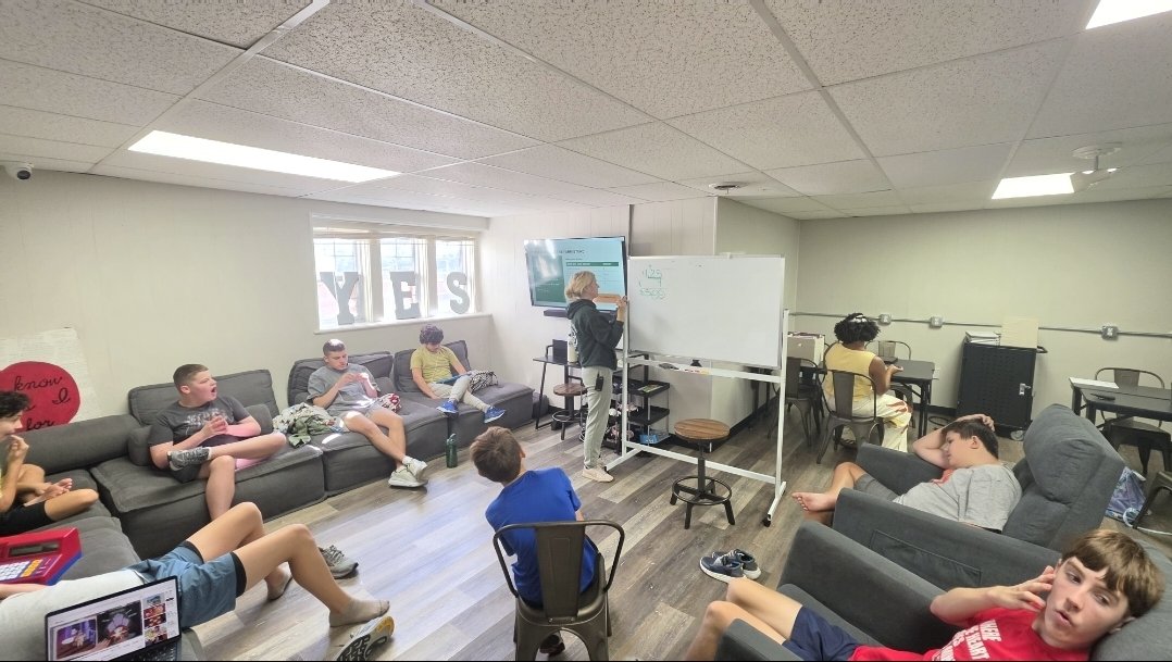 The group relaxes on couches during a session in the movehaus community room.