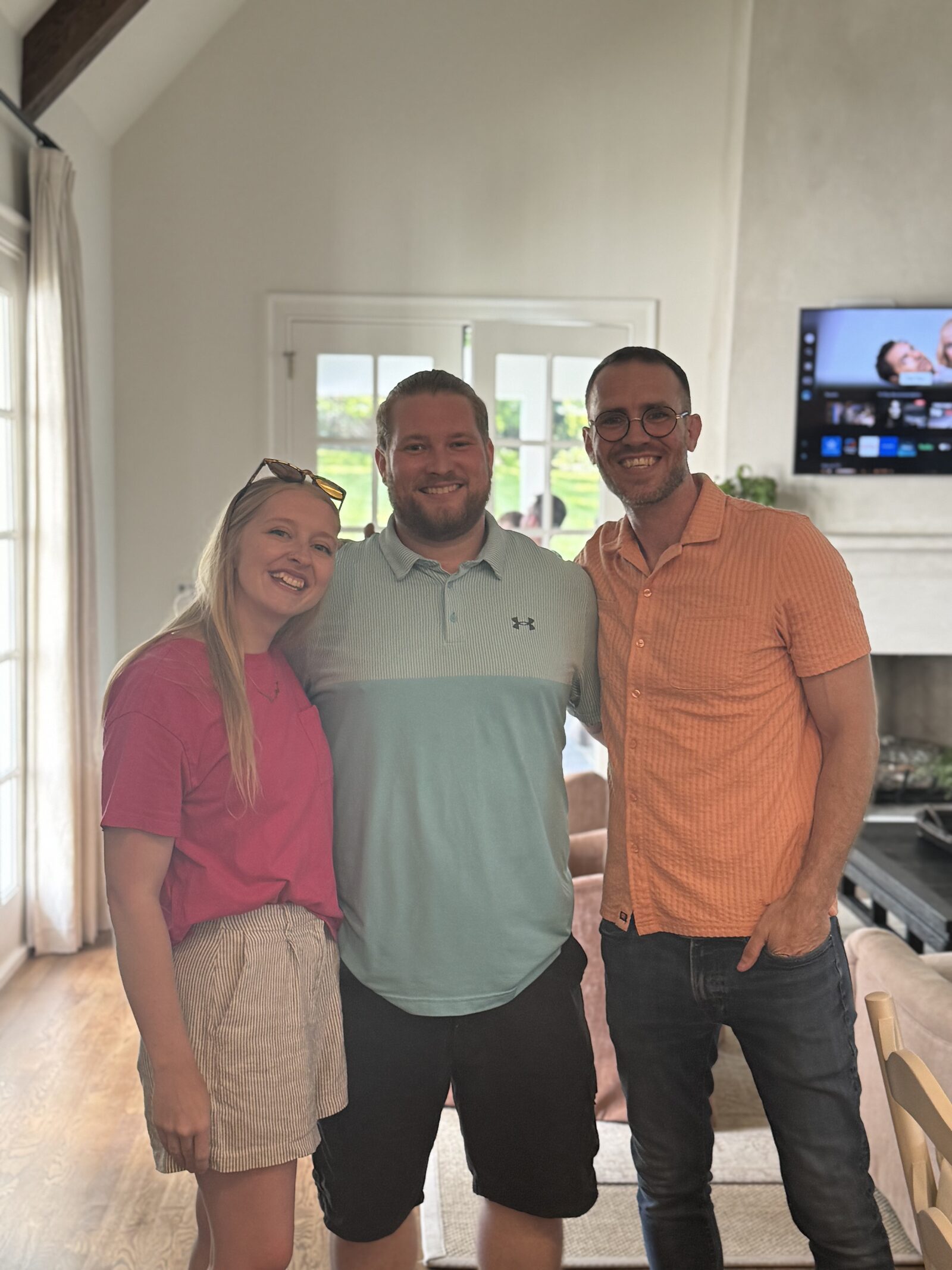 Baylee Cady, Jacob Cady, and Shane Hearing, left to right, standing together in a sunlit living room